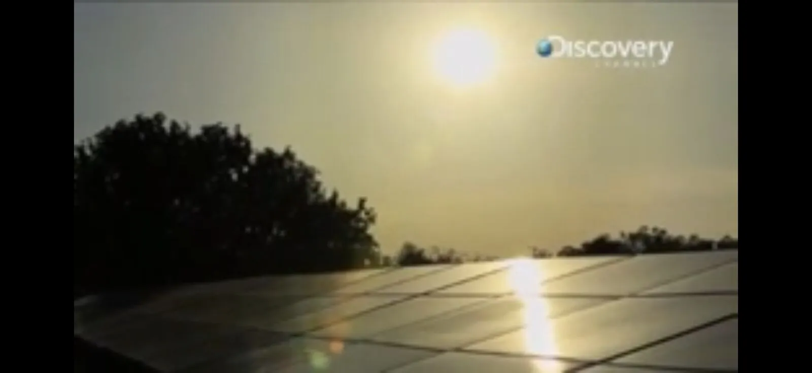 Sun shining directly over a row of solar panels — the central image of the Sun Fuel film on Discovery Channel.