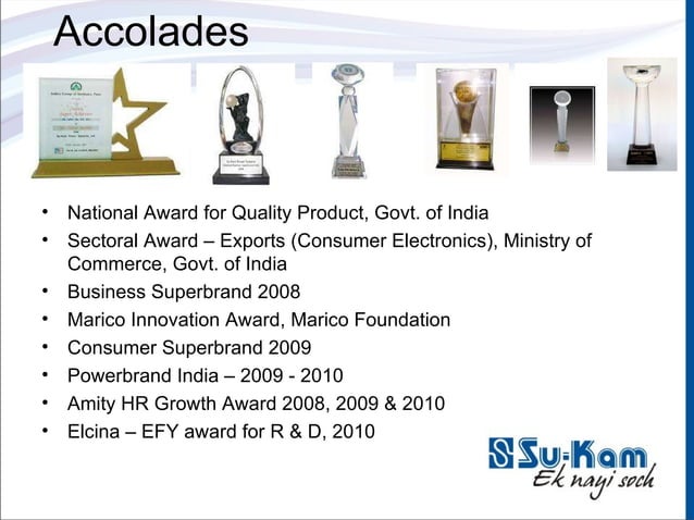 Su-Kam awards cabinet photograph showing National Award for Quality, Sectoral Export Award, Business Superbrand, Marico Innovation, Consumer Superbrand, Powerbrand India, Amity HR Growth and ELCINA-EFY R&D trophies lined up against a wall