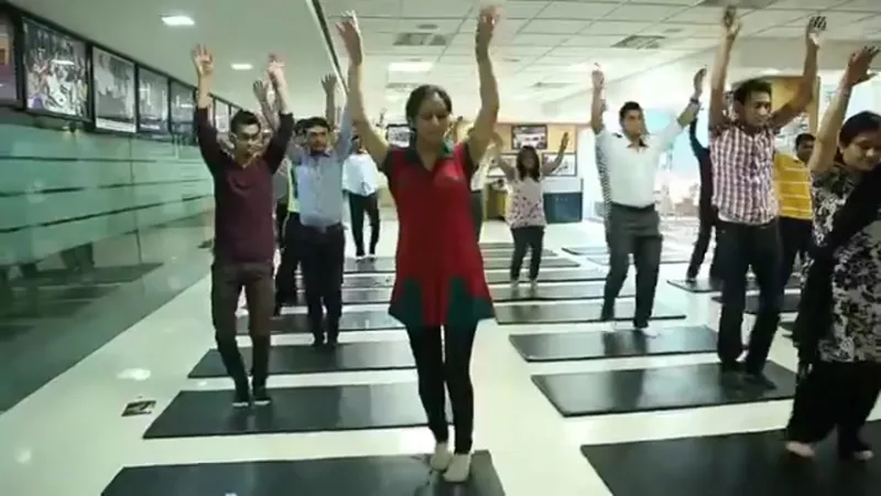 Su-Kam employees doing yoga in an office corridor — daily fitness as part of the work routine