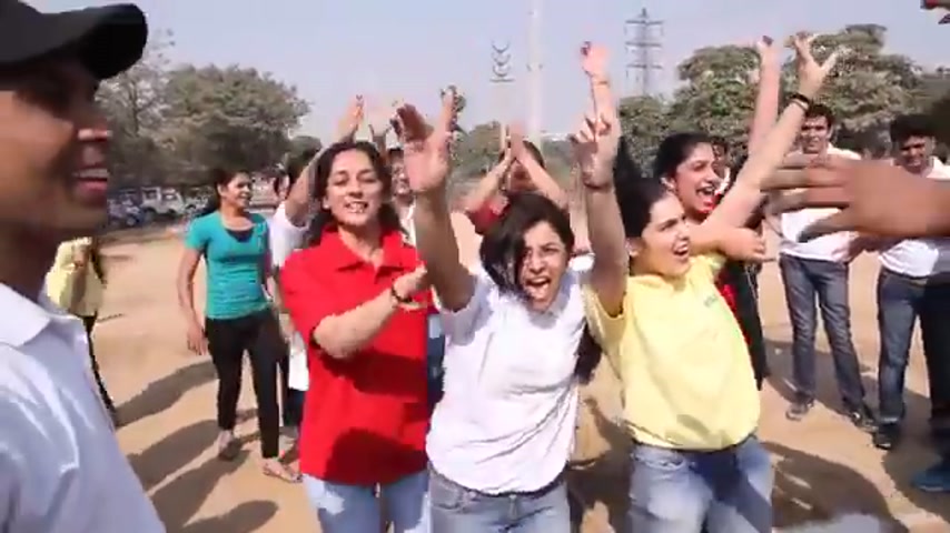 Employees cheering at an outdoor team event — one of the cross-plant gatherings that preceded major celebrations