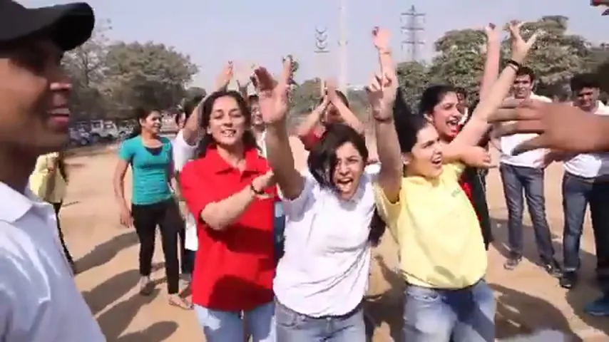 Employees cheering at an outdoor team event — one of the cross-plant gatherings that preceded major celebrations