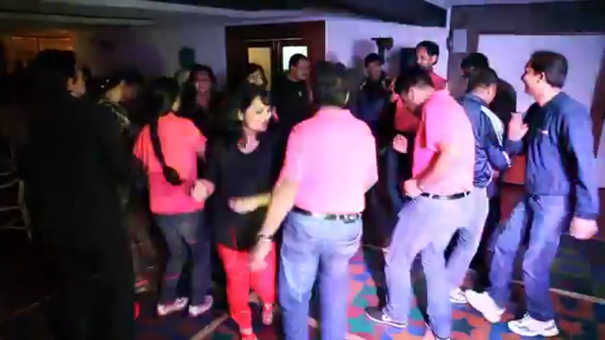 Su-Kamians dancing together under coloured lights at a Su-Kam celebration event