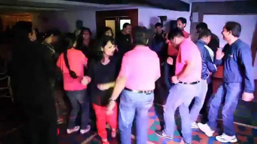 Su-Kamians dancing together under coloured lights at a Su-Kam celebration event